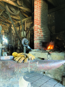 closeup of an anvil and fireplace for smithing.